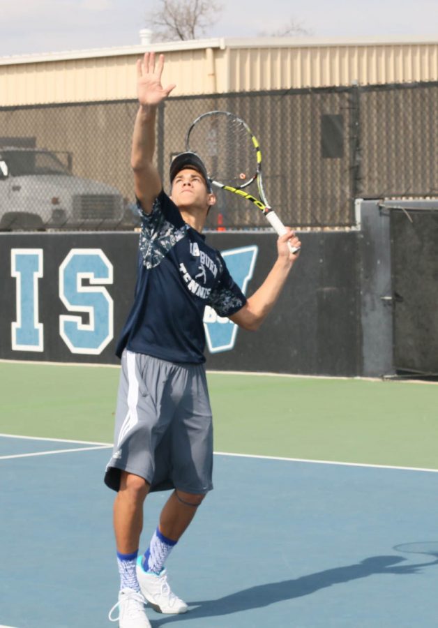 Zach Hampton poses to serve the ball in a doubles match
