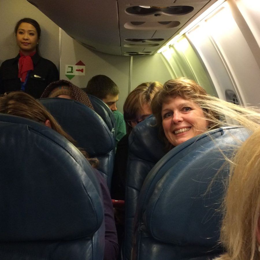 Faculty leader, Sharon Sullivan peeks around the airplane seats as our plane takes off from Kansas City International Airport. 