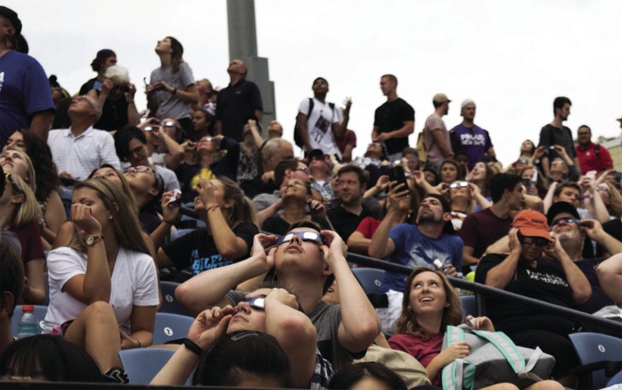 Eye to the Sky: Washburn students gather together at Yager Stadium to view the solar eclipse. Despite the cloudy weather, Ichabods were able to catch brief glimpses of the event.