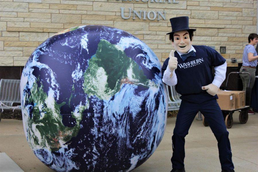 Thumbs up: The Ichabod mascot poses in front of a giant Earth ball adorning the Memorial Union Patio for Earth Day. The ball served as a focal point for the celebration.