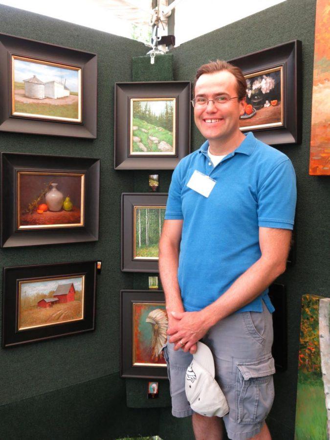 Justin Clements with his paintings at the 2019 Mulvane Art Fair.