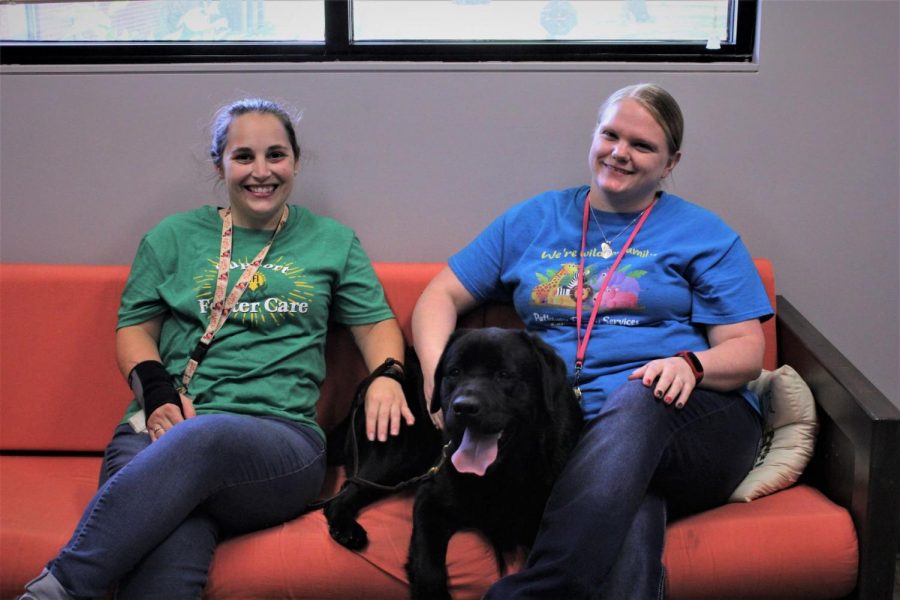 Couch canine: Titan and his two handlers, or moms, sit together on one of Pathways several comfortable couches. In the past two months, Titan has joined many kids for therapy sessions on these sofas, providing comfort and a sense of ease.