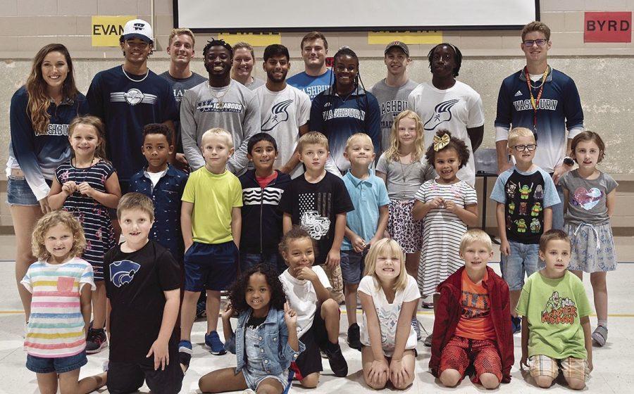 Role Models: Students at Wannamaker Elementary pose with Washburn track and field student athletes after a pep rally. Student athletes from a variety of sports volunteered at local schools the previous week.