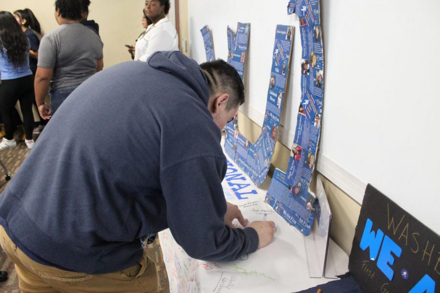 One of many: A Washburn student signs a banner expressing support for first-generation Washburn students. Many faculty, staff, and students were given the opportunity to do so thanks to We Are F1rst.