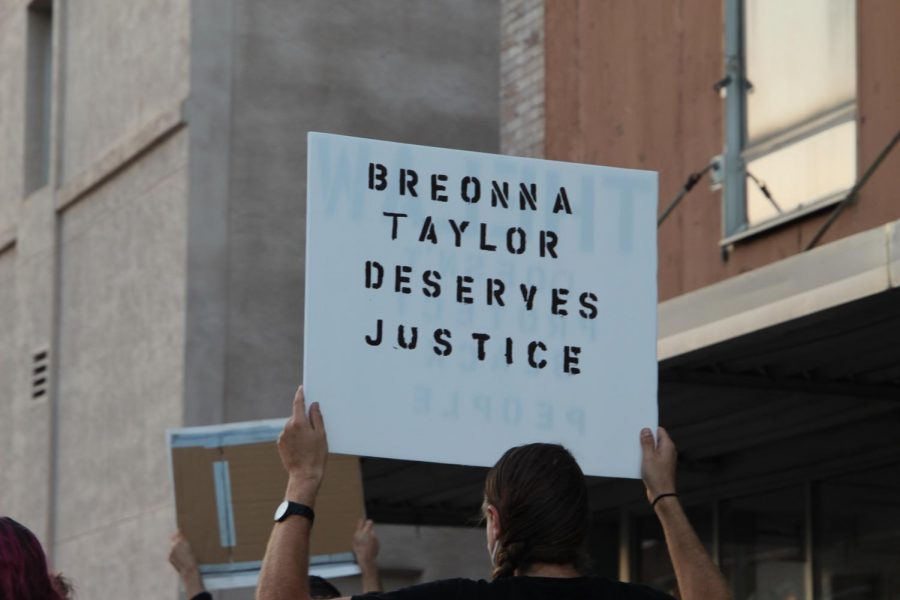 A protestor, participating in the Black Lives Matter-Topeka silent march/rally, holding a sign stating Breonna Taylor Deserves Justice. Breonna Taylor is a victim of injustice and wrongful acts from a police officer; which is one of the catalysts for many people to participate heavily in the Black Lives Matter movement.