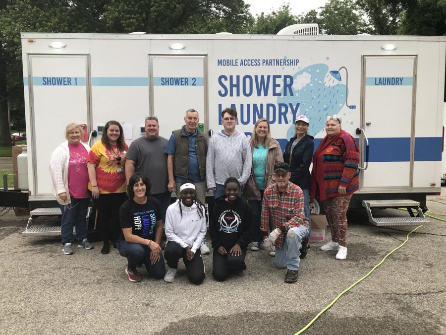 Were here to help: Volunteers from the Topeka Rescue Mission, Valeo Behavioral Health Care, KDHE, Positive Connections and the Oakland New Life Church gather for a group photo in front of a mobile shower and laundry facility provided by Valeo. They hope that their actions will make a change for the better in the community.