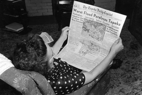 Bad news: A woman is shown reading The Topeka Daily Capital with a horrifying title that reads, Worst Flood Paralyzes Topeka.