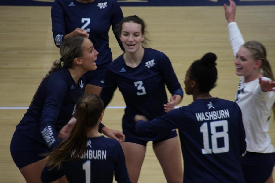 High energy: The team celebrates before huddling after winning a point in the third set on Oct. 1, 2021. Washburn would take the third set 25-12.