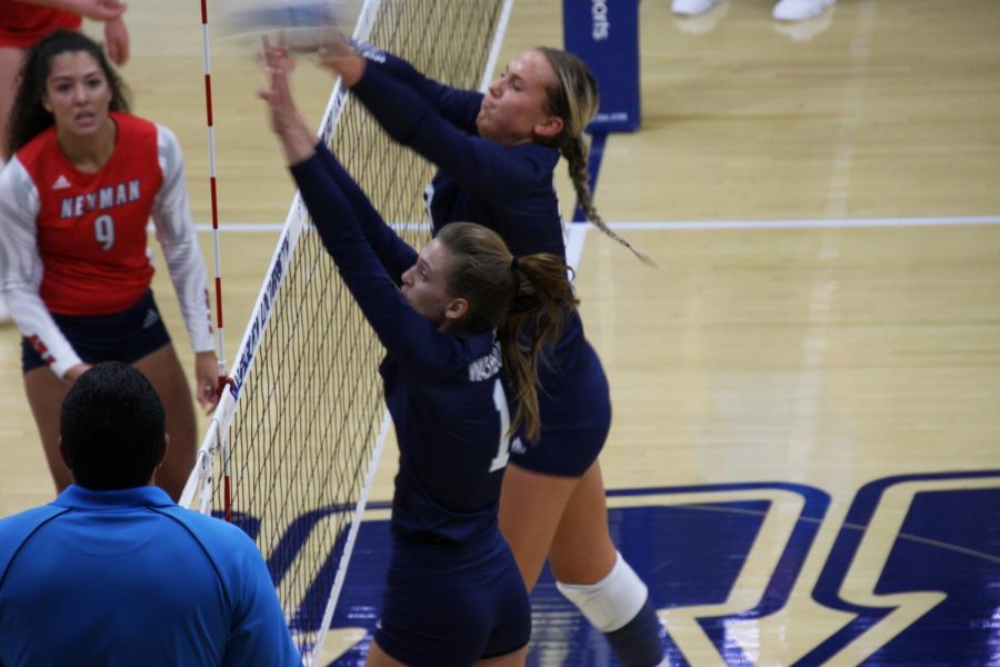 Team play: Senior outside hitter Genna Berg and senior middle hitter Allison Maxwell leap to block an attack from Newman on Oct. 1, 2021. The two combined to record 8 blocks in the match.