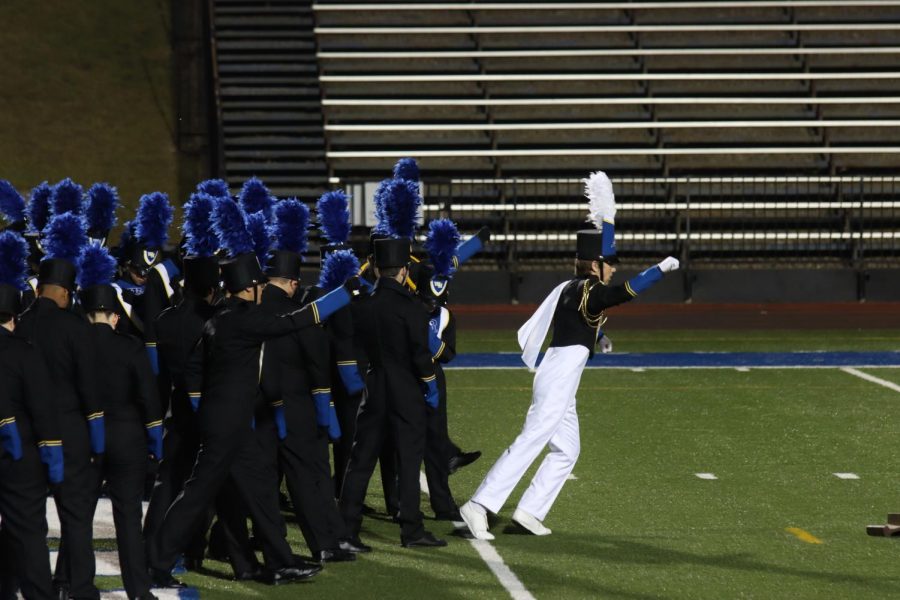 The first step: A band conductor runs onto the field, leading the way. The Washburn Rural Marching Jr. Blues were led by Luke Chaffee, Chris Exum, and Meredith Casey.