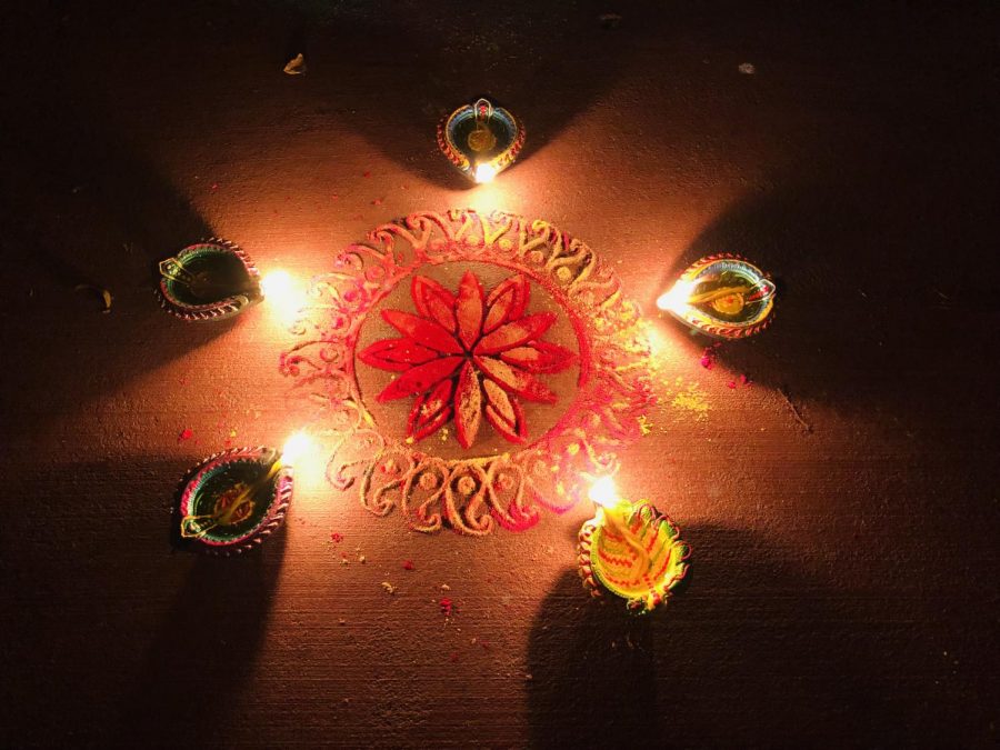 Diyo oil lamps were lit around the rangoli pattern made on the ground out of colored powder, on the occasion of the Tihar Festival party at International House.