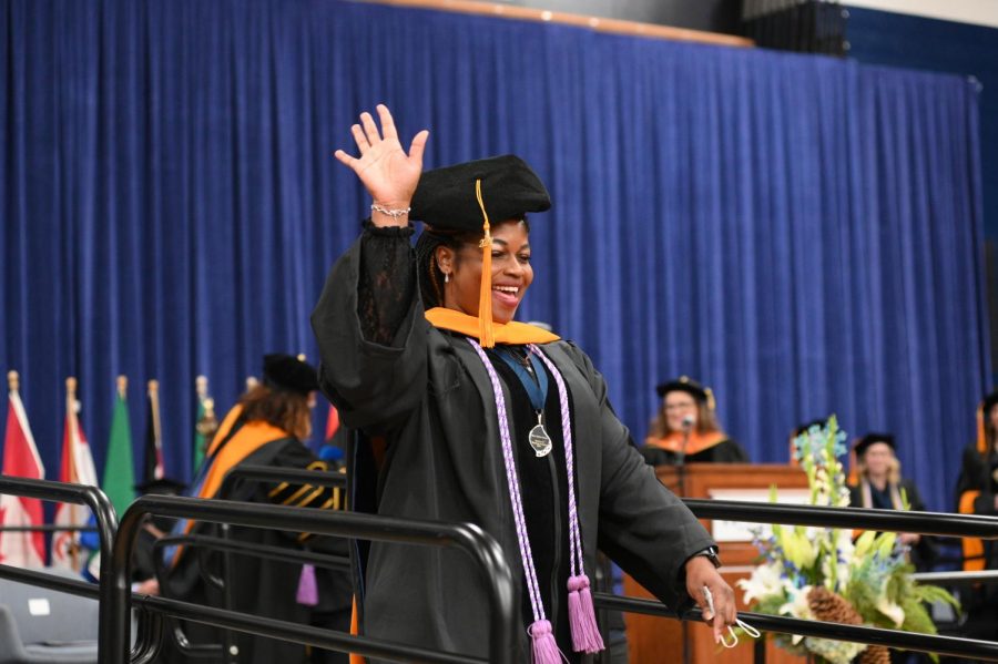 Graduate waves to the crowd walking of the stage. Fall commencement was held Dec. 17, 2021.