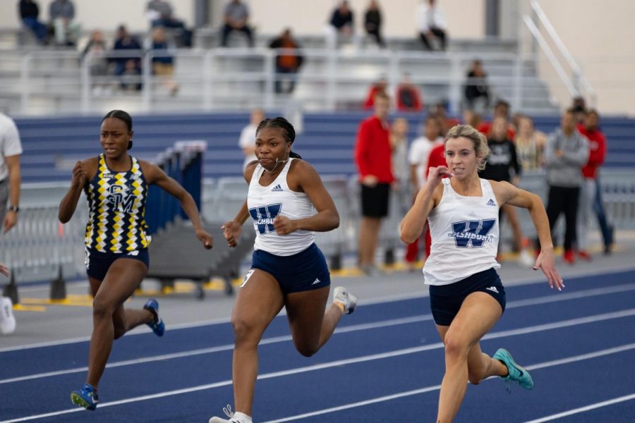 Isabella Hohl (right) and Alyssa Hutcherson (middle) give it all they have in the 60m dash. Hohl set a Washburn record and her old school record with the NCAA provisional mark of 7.64.