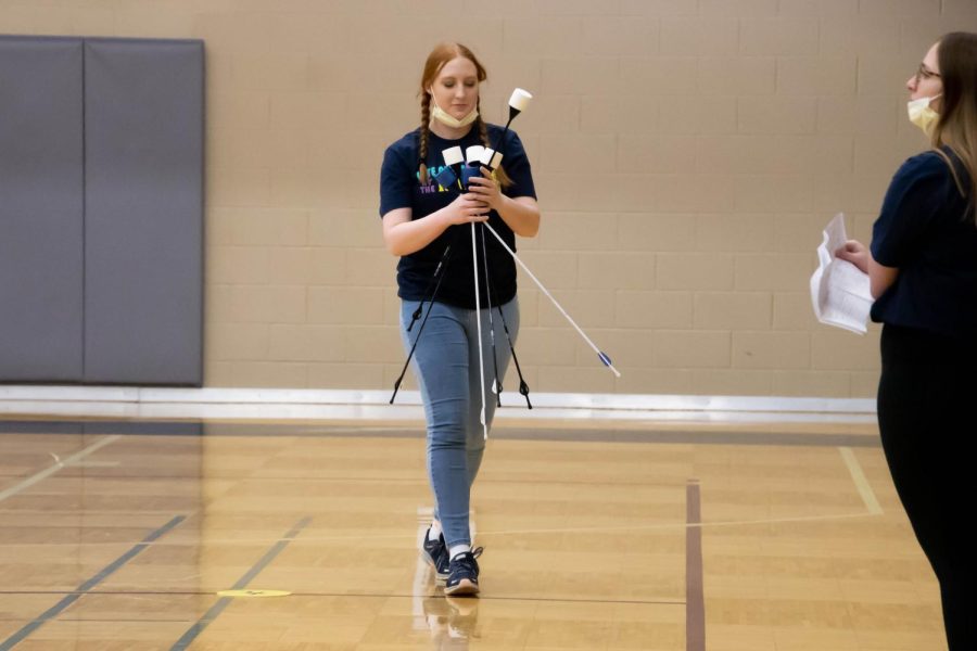 Angela Holthaus retrieves arrows for students. Holthaus, a nursing major and SRWC employee, worked the event.