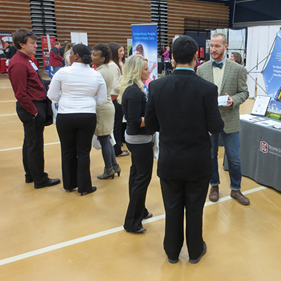 Attendees and representatives talk about careers in Lee Arena. The Career Fair has averaged about a hundred companies and grad schools present in recent years.