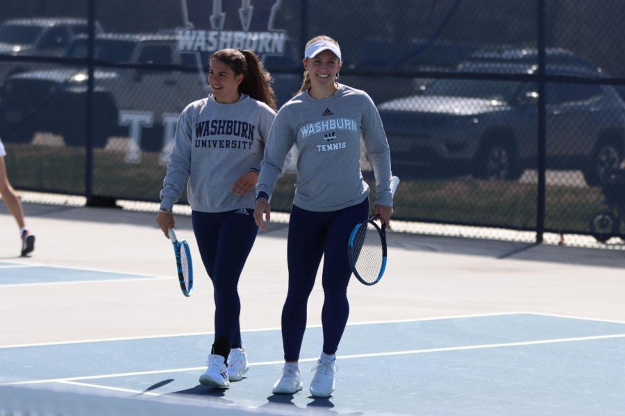 Sophomore Marta Torres (left) and junior Svea Crohn (right) smile after a point Mar. 26, 2022. Torres and Crohn won their doubles match 6-0.