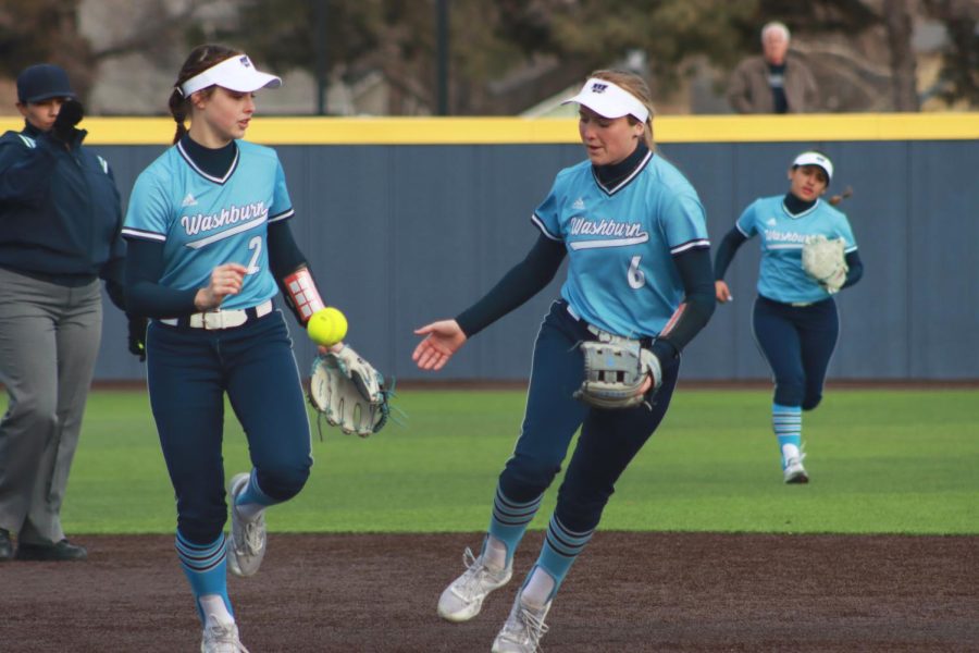 Washburn Authymn Schreiner (2) and Hadley Kerschen (6) run to the dugout Feb. 26, 2022, Topeka, Kansas.