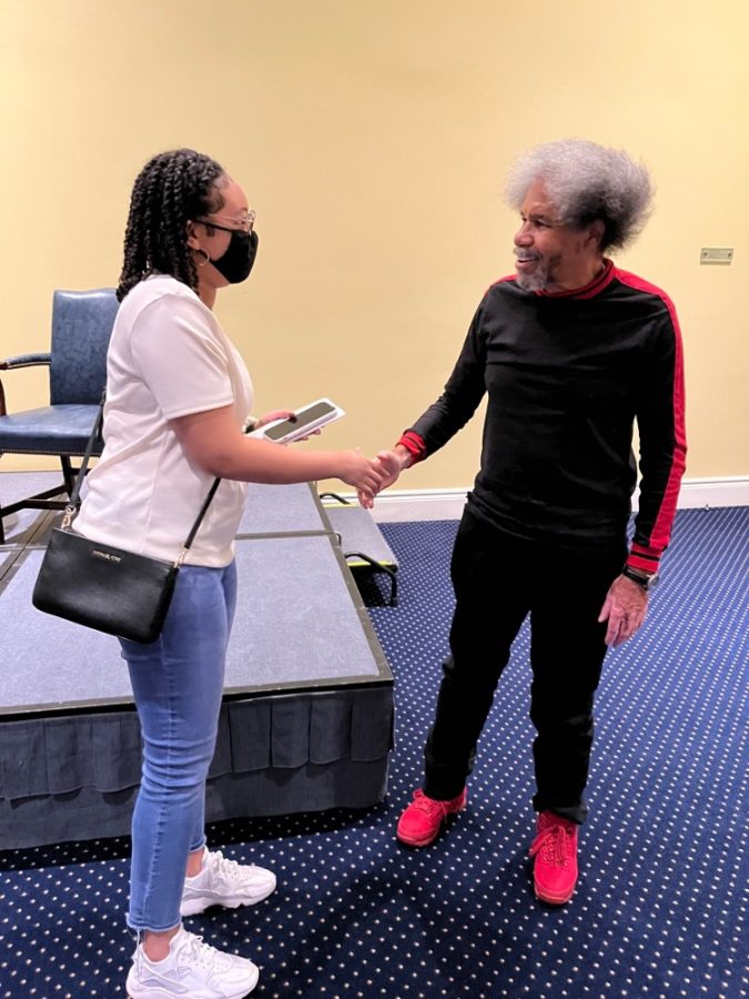 Sophomore Aja Carter and activist Albert Woodfox shake hands at WUmesters spring event. This event was held on Mar. 1, 2022.