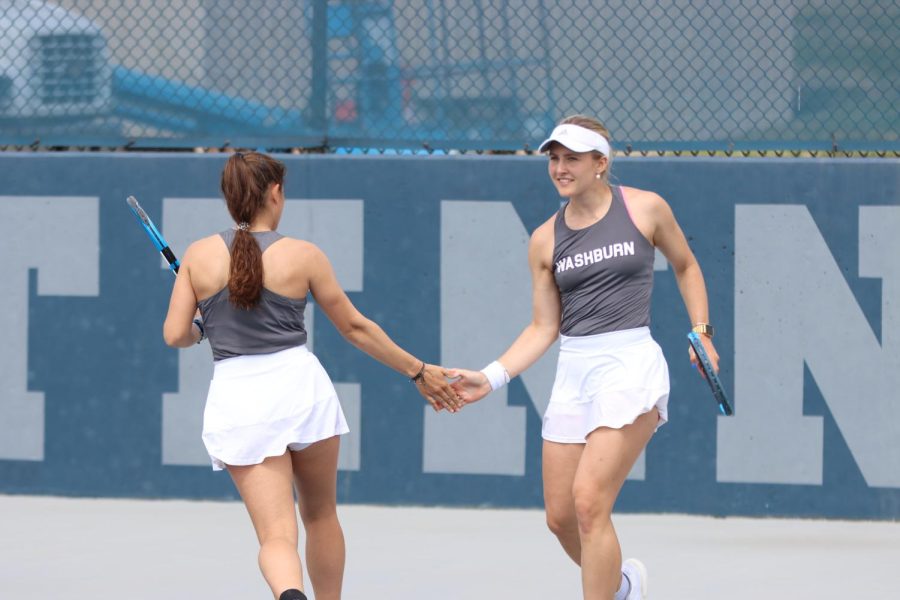 Sophomore Marta Torres (left) and junior Svea Crohn (right) high-five after a point March 29, 2022. Torres and Crohn won their No. 3 doubles match 6-1.