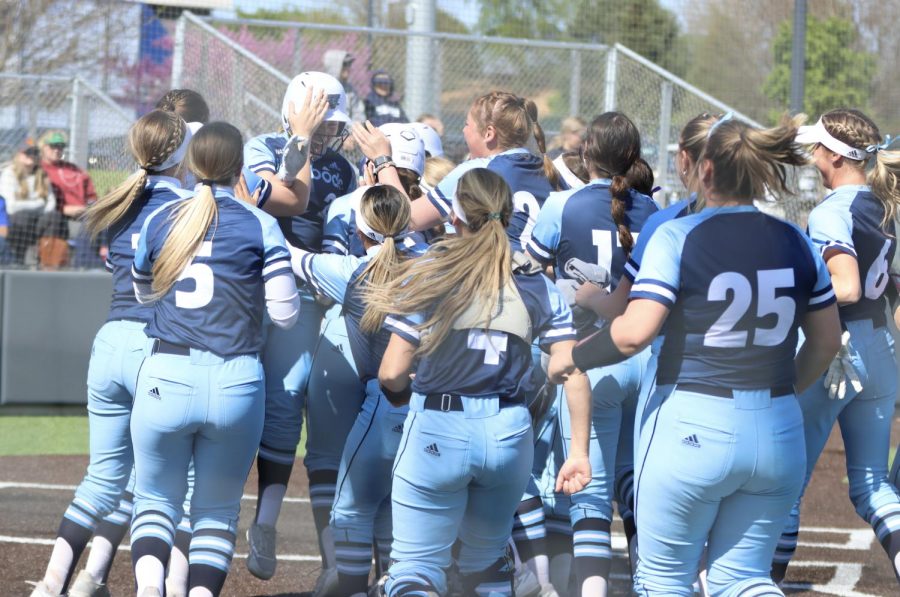 Washburns team mobs senior Ashton Friend after she hit a walk-off home run April 25, 2022. Washburn defeated Rogers State 2-0 in game one of the day.