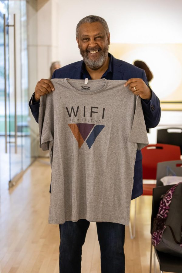Kevin Willmott, Academy Award winning director and screenwriter, holds up a WIFI Film Festival t-shirt after his filmmakers talk in the Rita Blitt Gallery at Washburn University. Willmotts filmmaker talk was part of the 2022 WIFI Film Festival.