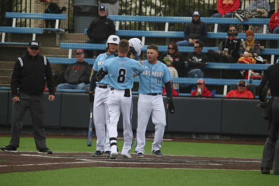 Senior Tyler Clark-Chiapparelli (middle) is greeted at home by seniors Quinn Waterbury (left) and Parker Dunn (right) after a home run April 30, 2022. Clark-Chiapparelli had two RBIs in the game.