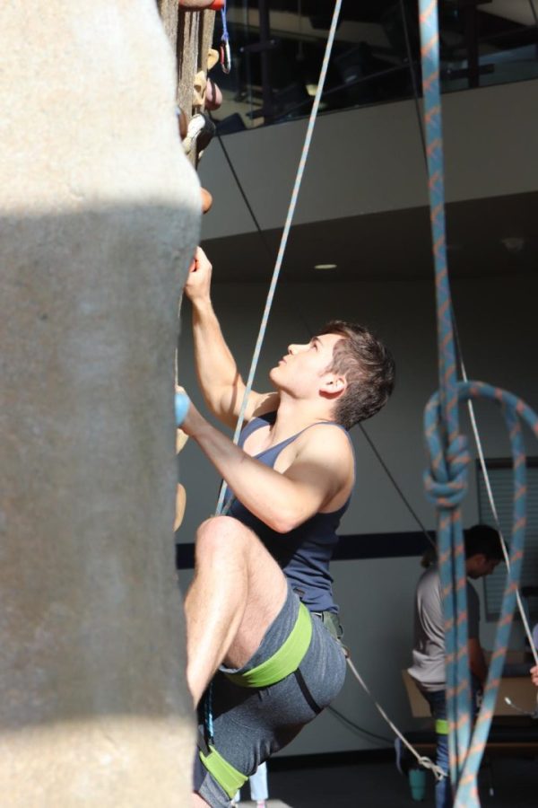 A+student+climbs+up+the+rock+wall.+The++Student+Recreation+and+Wellness+Center+held+the+Rock+the+Rec+event+on+Aug.+22%2C+2022.
