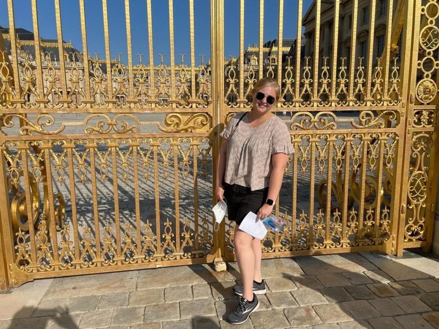 Abigail+McCrory+poses+in+front+of+golden+gates+at+the+Palace+of+Versailles+in+Versailles%2C+France.+Students+on+the+trip+were+able+to+tour+other+iconic+locations+in+Europe+such+as+the+Eiffel+Tower.