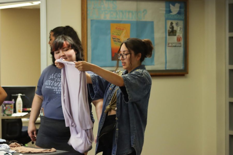 Analisa Chavez-Muñoz, senior in public administration, sizes up a shirt. There were many options for clothes to swap at the event.