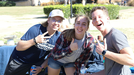 Freshman mass media major Eli McDaniel and freshmen psychology majors Carter Hiebert and Mayah Mumpower happily pose for a picture. Many friends attended the Homecoming tailgate to celebrate Washburn together.