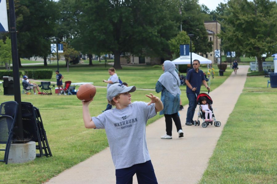Camden Hughes, brother of Washburn student Bailey Hughes throws a football. The Washburn Recreation and Wellness Center had many sports activites for individuals to participate in.