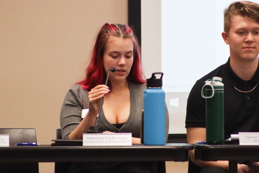 Communications and Marketing Director Katherine Cook collects votes on what color she should dye her hair. Members voted red or brown for their attendance question at the end of the meeting.