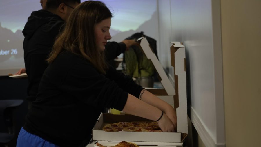 Meila Crowder, undeclared freshman, is grabbing pizza before activities at the Halloween Bash begin. There was a variety of pizza options for students to choose from at this event.