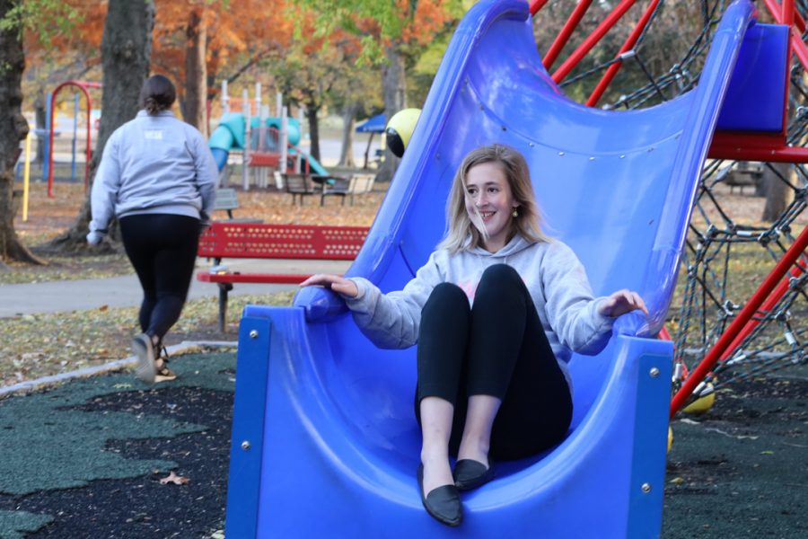 Senior criminal justice major Elizabeth Pendergrass slides down a slide. Toward the end of the social, members went to go play on the Gage Park playground. 