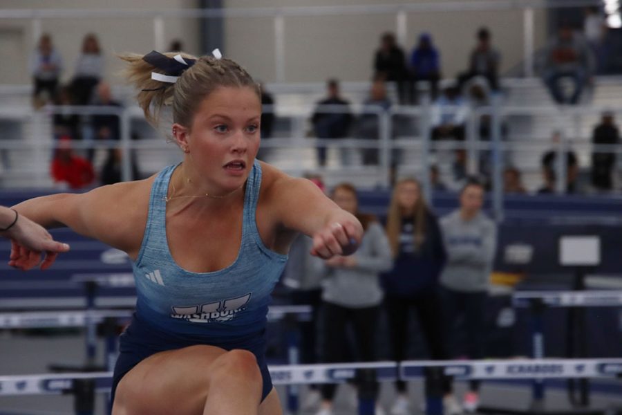 Ashley Heavner, freshman in mass media and public relations, jumps over the hurdle in the 60-meter hurdle finals. Heavner finished the race with a time of 9.26 and also competed in the 600-yard run with a time of 1:27.68.