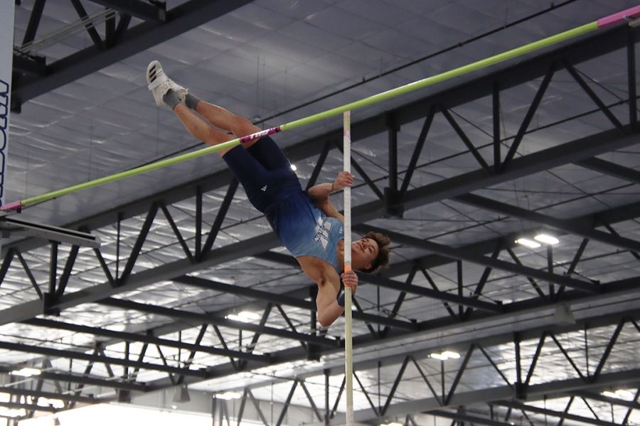 MacKobe Merwin, freshman in pre-physical therapy, pushes himself over the bar in the pole vault. Merwin placed ninth in the event with a height of 4.32 meters.