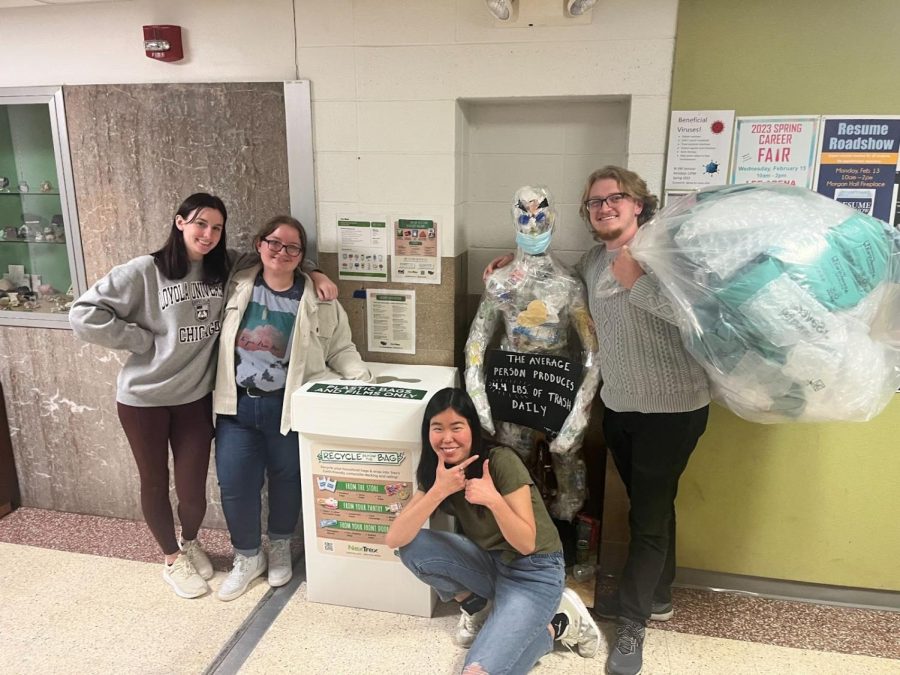 Biology Club members, sophomores, Mary Tyler, Desiree Thimesch, along with seniors, Samantha Kim, (Trashman) and Chris Preister, all biology majors, pose in front of their recycling collection box. On the first day the program had gathered almost 5 pounds of plastic waste.