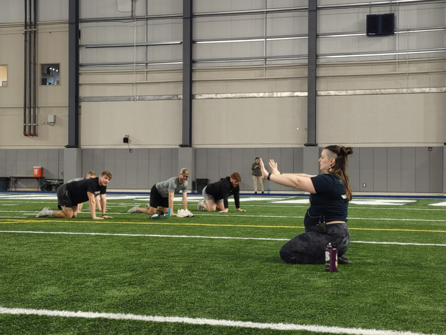 Carolyn Jones, yoga instructor and residential living assistant director of student engagement, demonstrates a yoga position for the participants. The yoga session gave community members a short break from their day so they could stretch and relax.