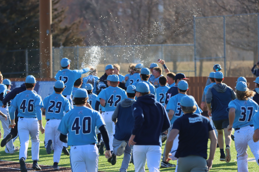 The team runs out onto the field to celebrate and throw water over Adams to celebrate the final point scored. The game ended with a score of 2-3 with Washburn winning the first game of the series.