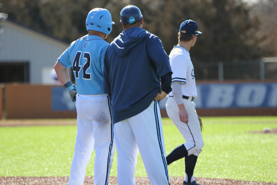 Andrew Schimidtlein, junior in finance, talks with coach Harley Douglas after advancing to third base. Schimidtlein ended up getting another point for Washburn baseball in the bottom of the seventh.