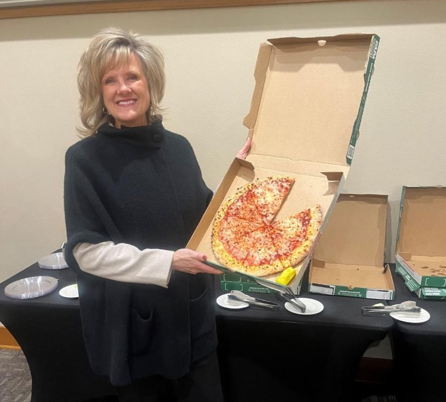 JuliAnn Mazachek, president of Washburn University, models with a cheese pizza. Mazachek shared not only pizza that night, but also nuggets of knowledge on how to be a successful leader. 