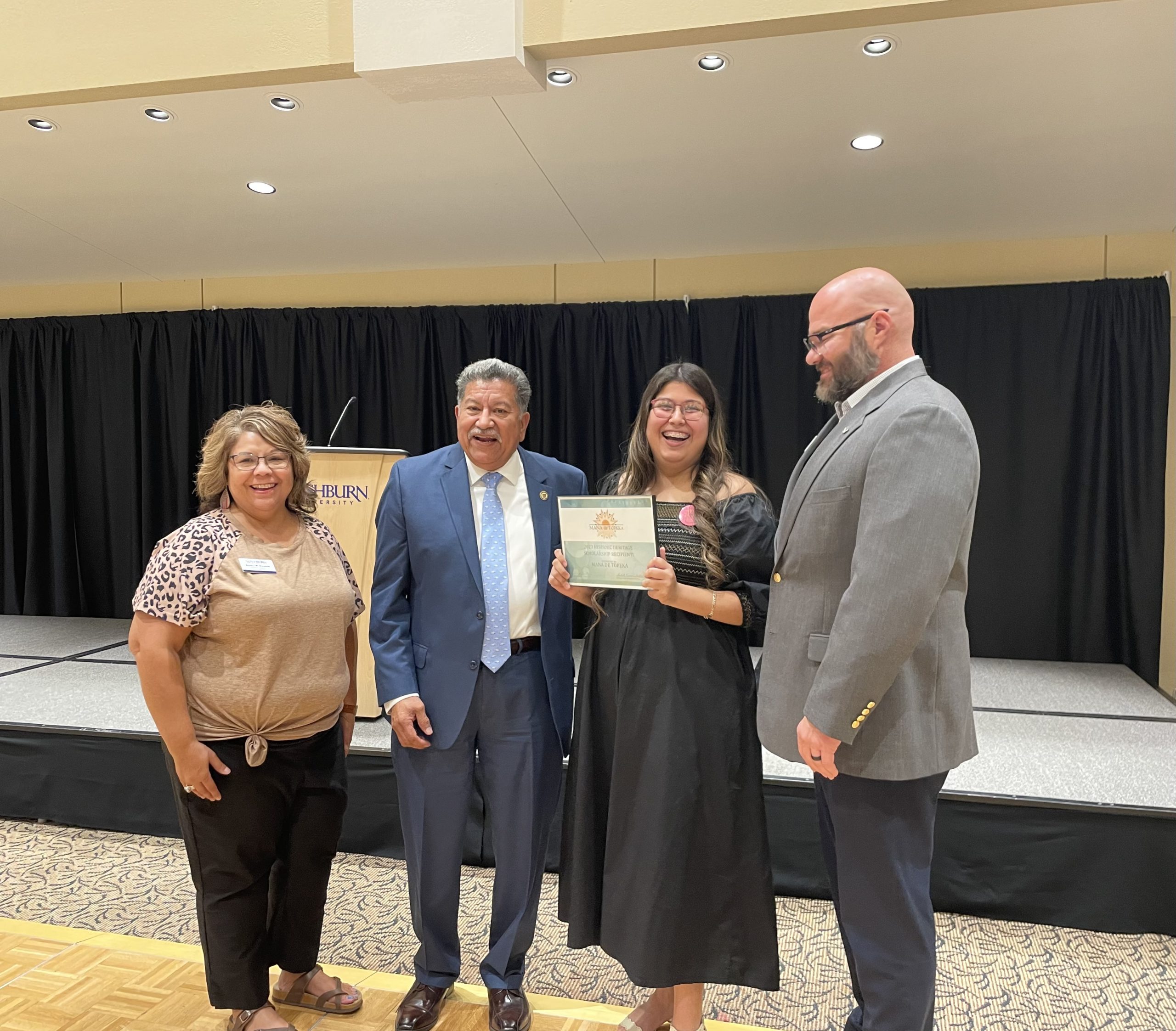Mariet Delgado, junior finance and management major, receives a $500 scholarship as the Hispanic Heritage Month Banquet was coming to a close. 
The scholarship was provided by Mana De Topeka, local chapter of MANA, a national Latina organization.

From left: Angela Valdivia, Career Services assistant director, Michael Padilla, Topeka mayor, Delgado and Eric Grospitch, vice president of Student Life.