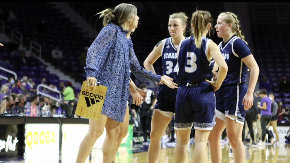 Yoder coaches and encourages her team to win the game. Yoder served as the assistant coach for the Washburn womens basketball team from 2019 to 2022.