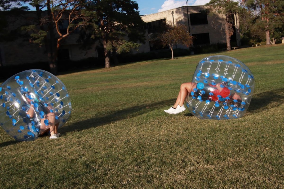 Lanaya Hada (left),  a sophomore elementary education major and Alyssa Britt (right), a freshman sonography major, enjoy the inflatable balls even though they kept getting knocked over. This was a popular activity throughout the evening.