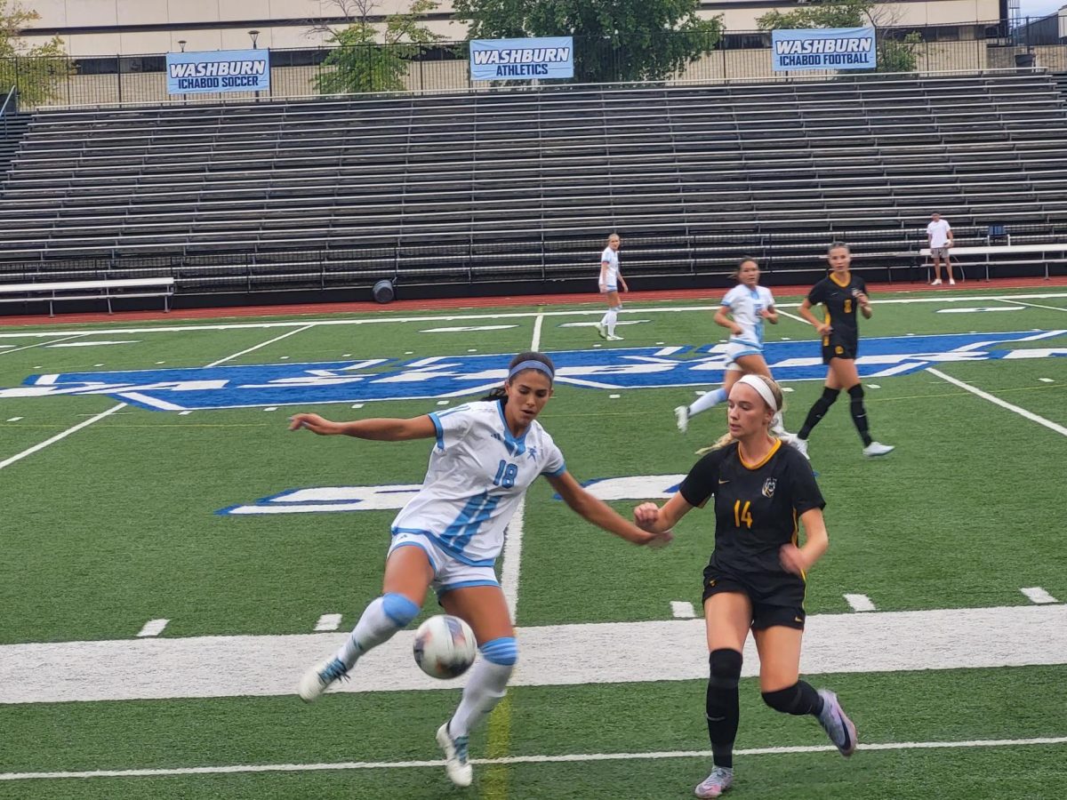 Riley Wells, junior forward, protects the ball from Fort Hays junior defender, Gracen Chaney . The ball however, was kicked out and thrown back into play by Taylor Bockover, junior defender.
