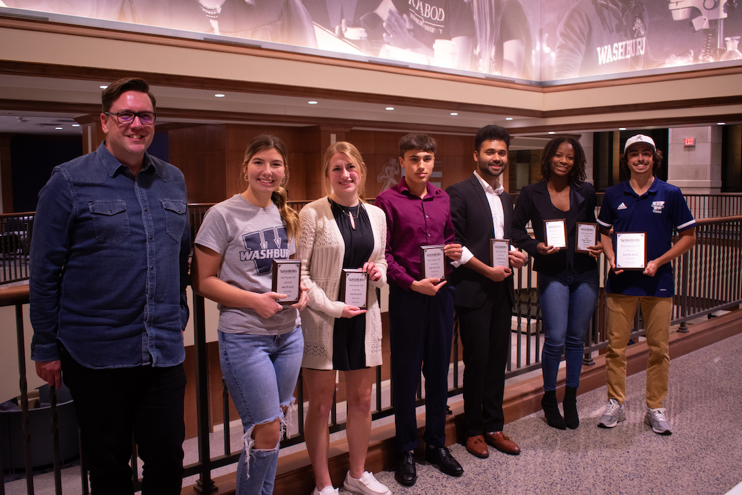 All six finalists stand with their award plaques alongside the chair of the communication studies department, Jim Schnoebelen. Each finalist received a scholarship, donated by the Nall family, with the amount depending on their final placements.