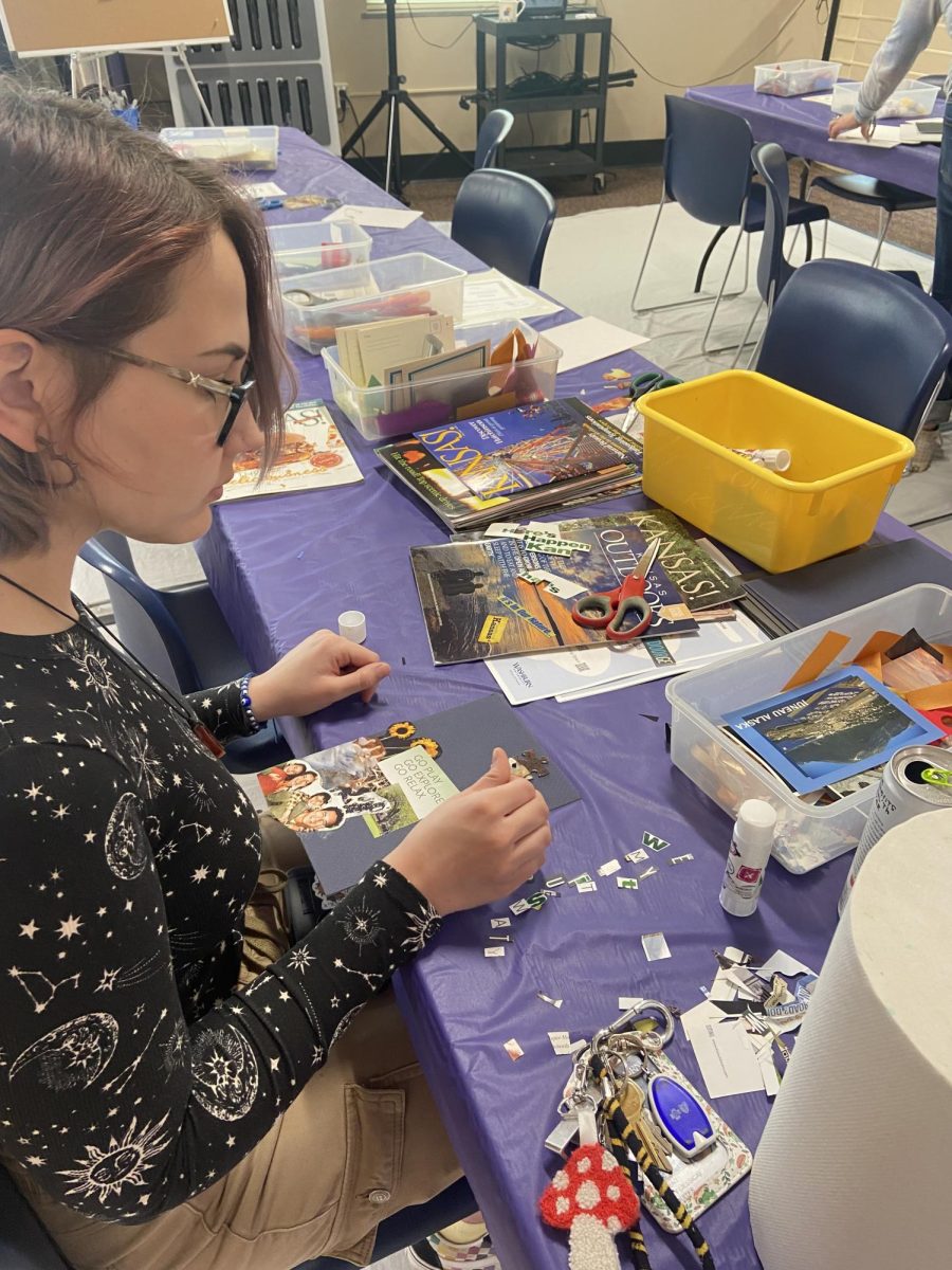 Corey Rosquites, freshman nursing major, decorates her paper with collage. The artmaking popup provided a relaxation time for students who are approaching their finals.