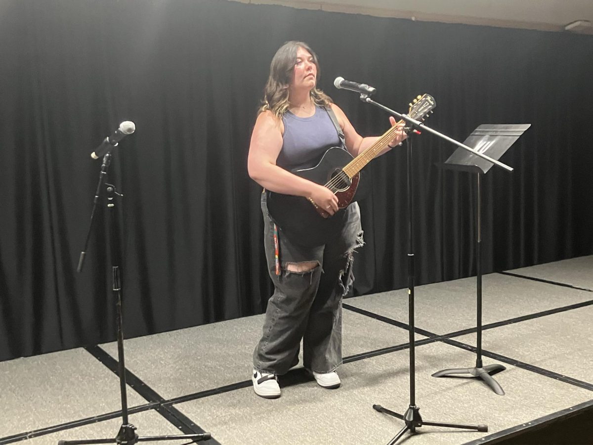 Hannah Andersen, senior mass media major, prepares her guitar for the talent show. All contestants prepared the stage for their performances.