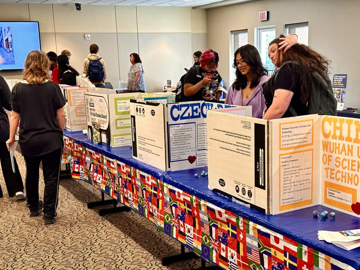 Students explore study abroad opportunities at the International Programs stand during the Major and Minor Fair. All of them were actively inquiring about opportunities to travel abroad.