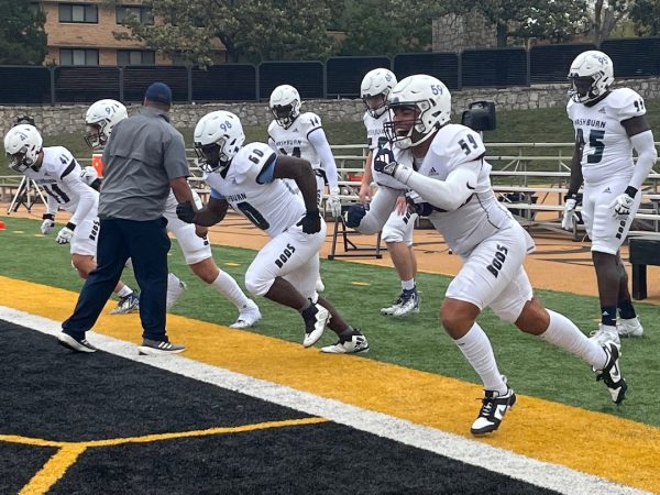 The Washburn defensive line along with assistant coach Malen Luke warms up before kickoff. The defensive line held the Hornets run game to 98 rushing yards.
